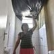 Eliane Gomes, irmã de moradora do bloco 14 do Residencial Vila Velha, em Jabaeté, mostra queda do teto do banheiro