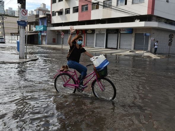 Carros e ciclistas enfrentam a rua alagada na Avenida Jair de Andrade em Itapoã, Vila Velha por Fernando Madeira