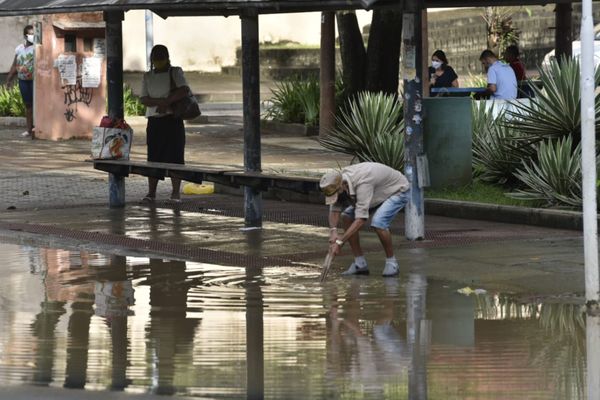 No bairro Caratoíra, em Vitória, um homem tenta desentupir um bueiro com um pedaço de madeira por Ricardo Medeiros