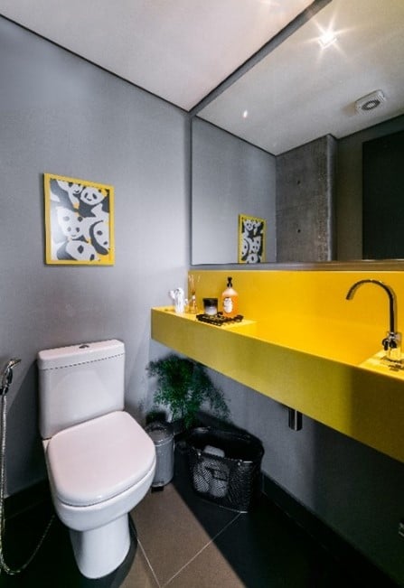 Nesse lavabo, a bancada em quartzo amarelo compõe com o cinza das paredes e do piso | Projeto: Liv’n Arquitetura |  por Guilherme Pucci