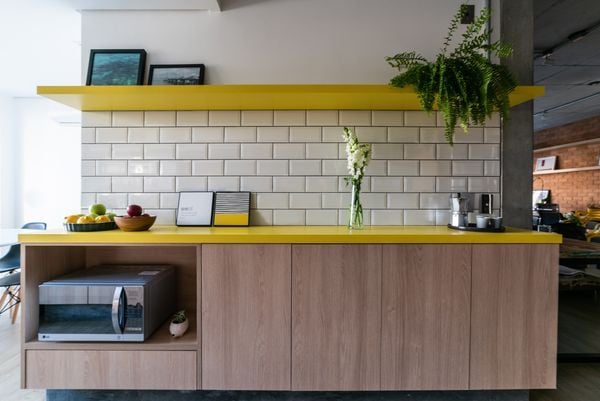 O amarelo tomou conta da bancada e da prateleira desta cozinha, criando um contraste com a base neutra | Projeto: Liv’n Arquitetura |