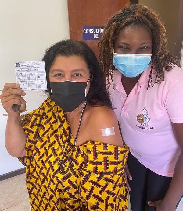 Após ser vacinada contra a Covid-19, Regina Casé posa com a agente de saúde e mostra carteira de vacinação