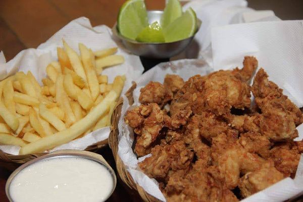 Porção de frango frito com acompanhamento do Frangozinho Butiquim, em Anchieta