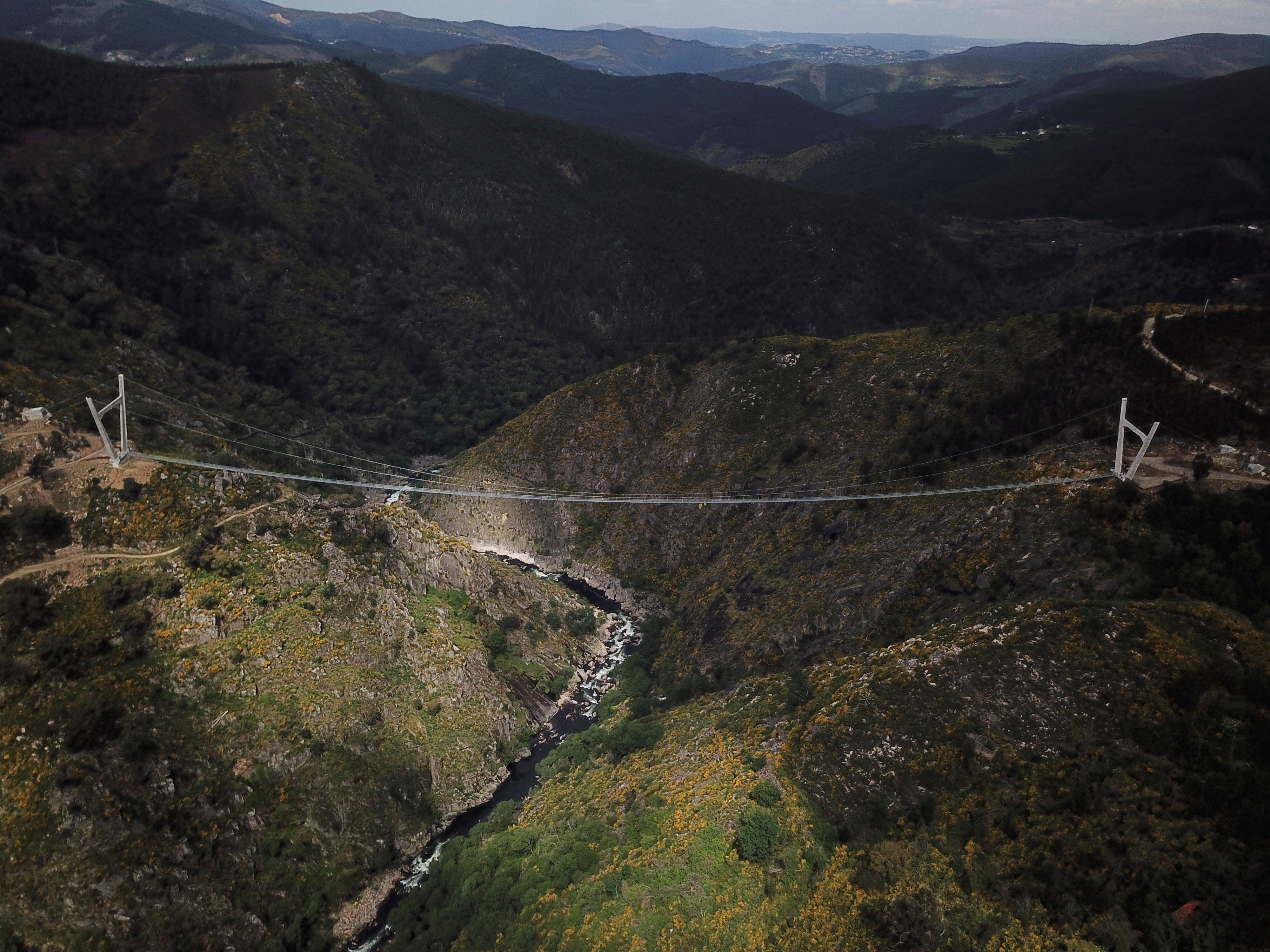 A ponte está escondida entre montanhas, dentro do Arouca Geoparc, a 175 metros acima do Rio Paiva 