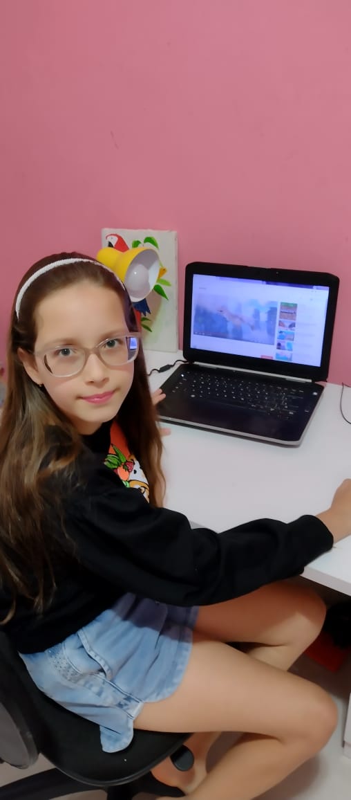 Mainy, de 10 anos, se senta diante do computador das 13h às 17h30 para participar das aulas on-line durante a pandemia.