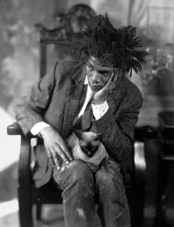 O talentoso pintor neo-expressionista americano Jean-Michel Basquiat fotografado com seu gatinho, em 1982. Vale lembrar que ele retratou por diversas vezes os felinos em seus quadros.