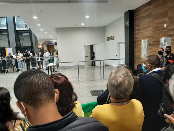 Pessoas aguardando no saguão de desembarque internacional, no Aeroporto de Vitória por Ana Clara Moraes