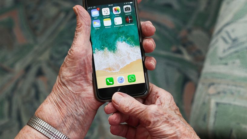 Idosos tenta usar um telefone celular