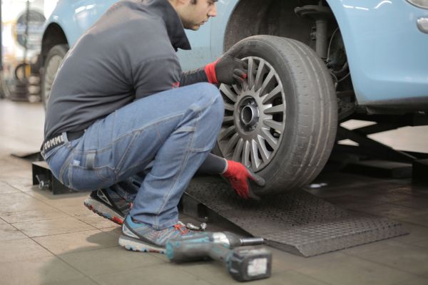 Homem troca o pneu do carro 