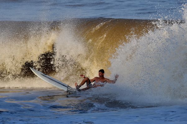 Surfistas aproveitam o mar de ressaca para curtir as ondas na Praia de Camburi, em Vitória