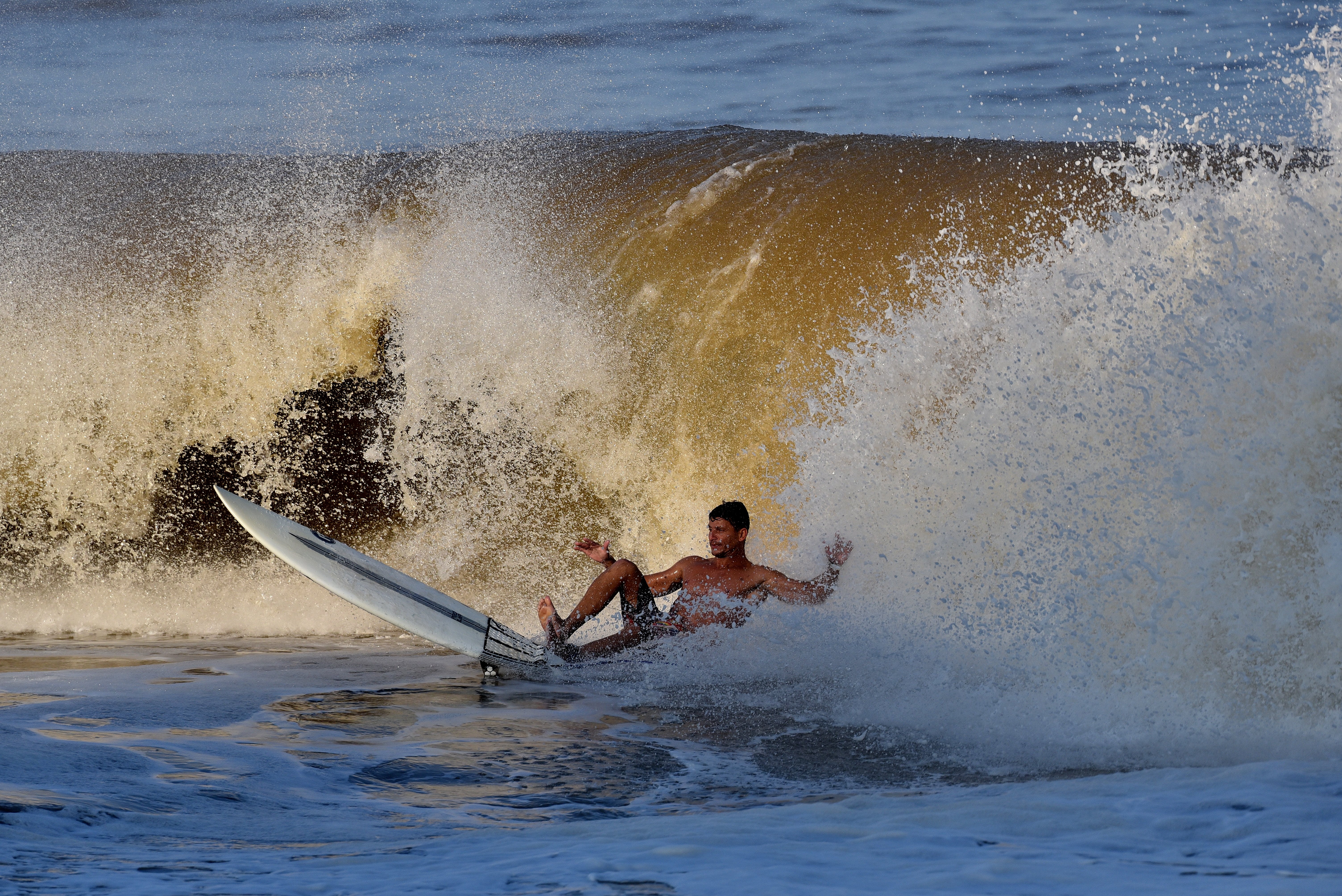Surfistas aproveitam o mar de ressaca para curtir as ondas na Praia de Camburi, em Vitória