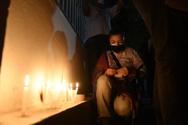 Estudantes acendem velas no muro de escola em Jardim Camburi