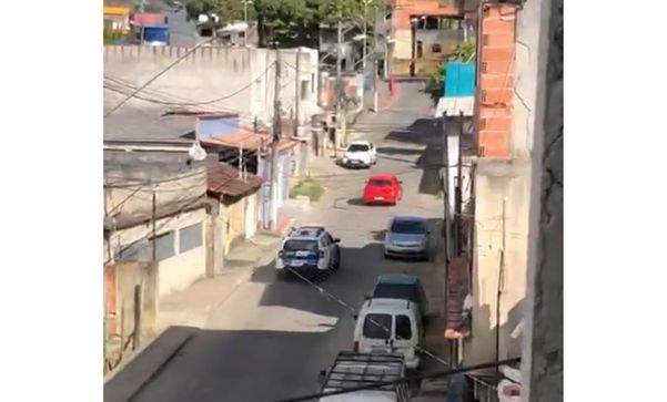 Viatura da PM perseguindo carro vermelho em uma rua do bairro São Marcos II, na Serra