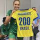 Alexandra Nascimento segura camisa do Brasil com seu nome e o número 200