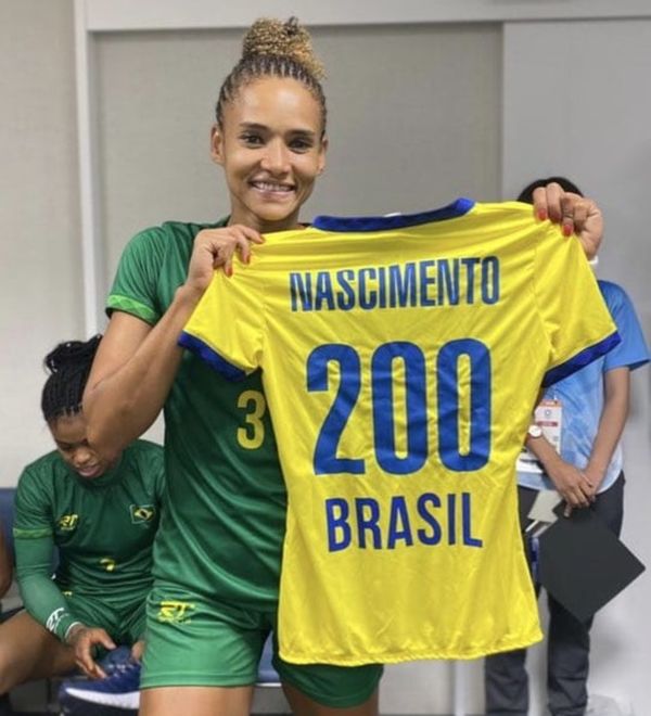 Alexandra Nascimento segura camisa do Brasil com seu nome e o número 200