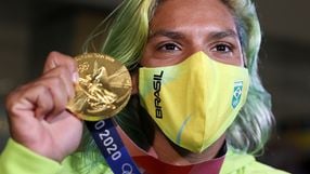 Ana Marcela Cunha exibiu com orgulho a medalha de ouro ao desembarcar no Brasil