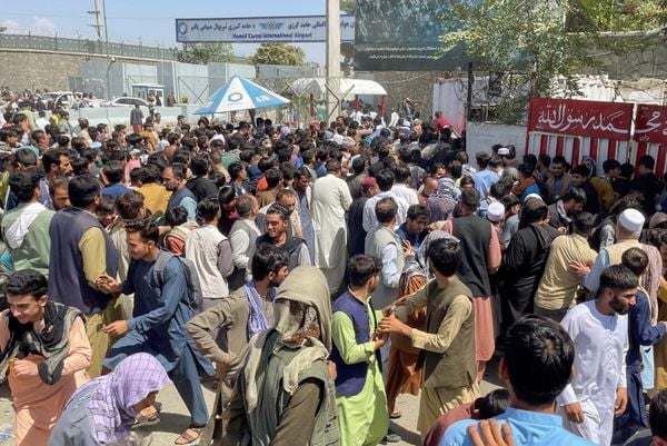 Afegãos tentam entrar no Aeroporto Internacional Hamid Karzai, em Cabul, em meio à tentativa de fuga após o Taleban entrar na capital