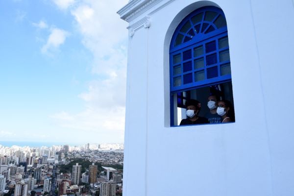 Família do DF, com máscara, observa a bela paisagem de uma das janelas do Convento da Penha