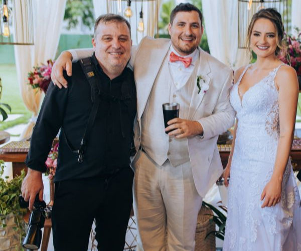 Adam Cristian Shcmitz Dias ao lado de noivos que fotografou. Crédito: Acervo pessoal