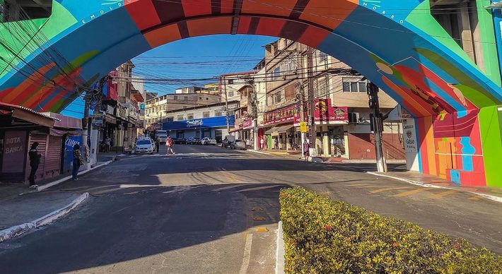 Nas paredes da construção, como também nas escadarias ao lado, imagens multicoloridas de catraieiros, bondinho e os bares boêmios da região