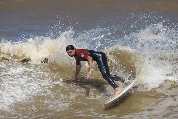 Surfistas aproveitam ondas para cair na água da Praia de Camburi, em Vitória
