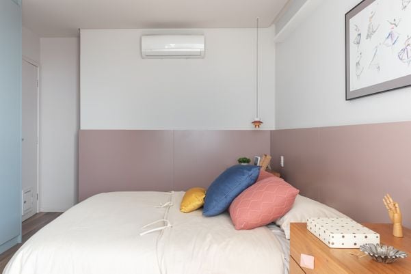 Aqui, a meia parede tem a função de imitar uma cabeceira de cama. por Camila Santos
