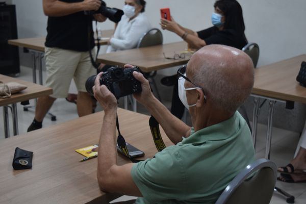 Participante do encontro fotográfico de A Gazeta manuseia equipamento durante bate-papo  por A Gazeta