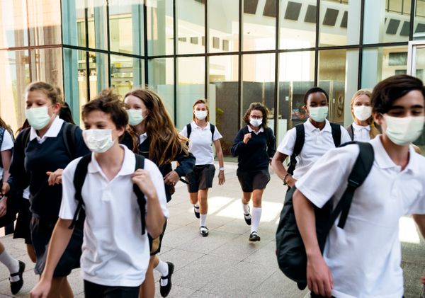 Alunos do ensino médio usando máscara na saída da escola