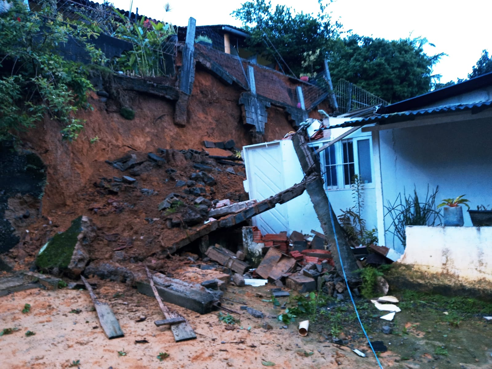 Muro de arrimo desaba sobre casa em João Neiva