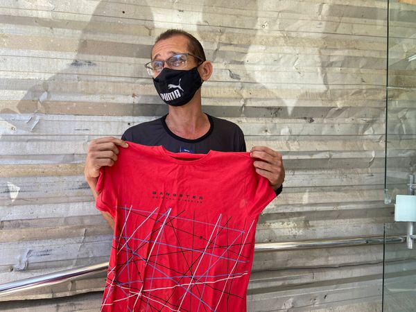 Renner, pai de Raphael, segura uma camisa do filho, emocionado