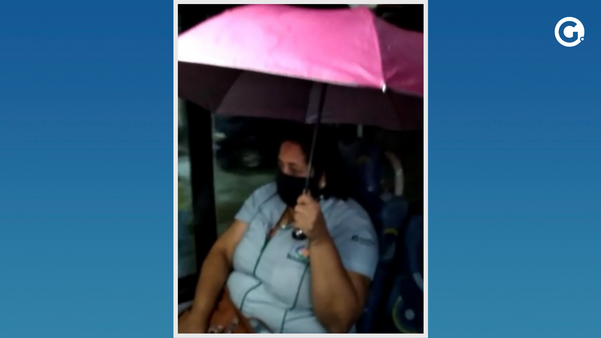 Mulher abre guarda-chuva dentro de ônibus para se proteger da chuva em São Mateus