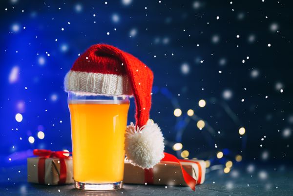 Copo de cerveja com presentes de Natal e chapéu de Papai Noel