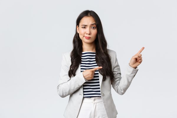 Business, finance and employment, female successful entrepreneurs concept. Skeptical and hesitant young asian businesswoman dont trust this promo, smirk doubtful and pointing upper right corner.