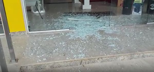 Porta de vidro da loja quebrada por criminosos 