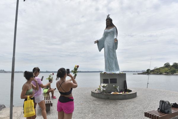 Pessoas levando flores para Iemanjá, em Vitória