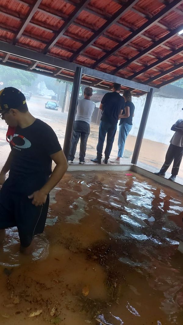 Algumas pessoas subiram em uma mureta para escaparem da água na capela mortuária de Coronel Borges por Redes Sociais