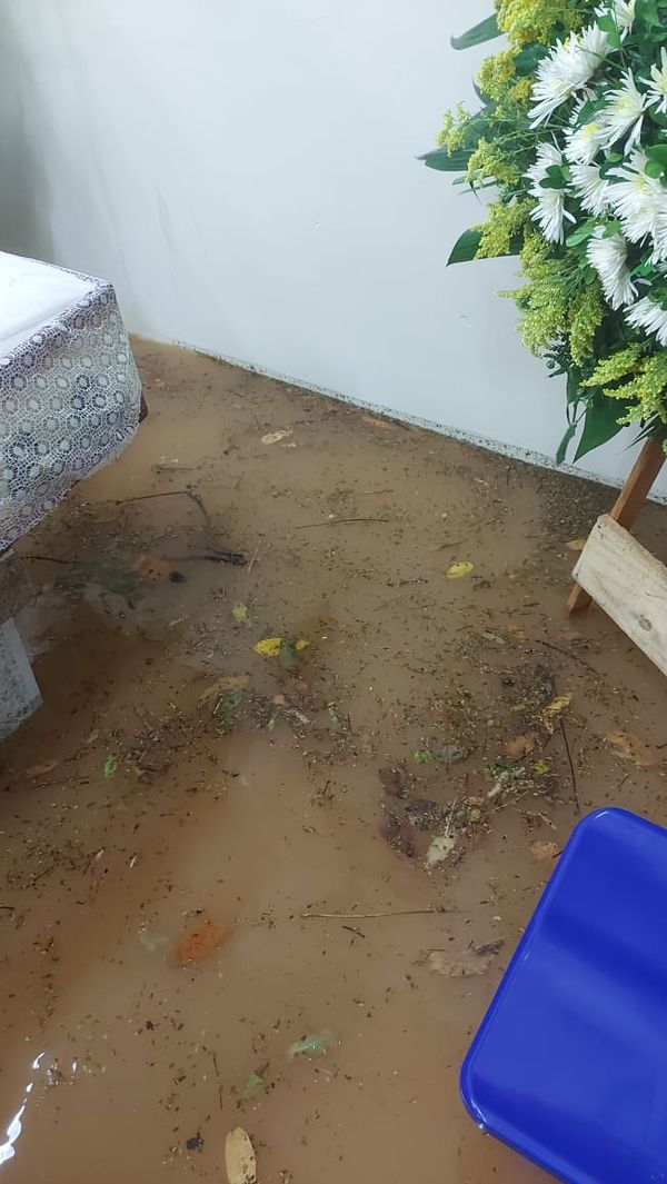Água da chuva alagou até área onde estavam o caixão e uma coroa de flores por Redes Sociais