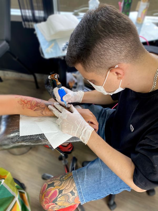 O tatuador profissional Walace Libardi de Miranda fazendo uma tatuagem em um cliente