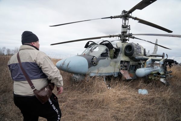 Homem observa um helicóptero russo Ka-52 após um pouso num campo nos arredores de Kiev, na Ucrânia, nesta quinta-feira (24)