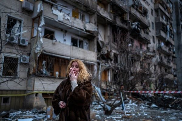 Natali Sevriukova do lado de sua casa após um ataque com foguete na cidade de Kiev, na Ucrânia, nesta sexta-feira (25/02)