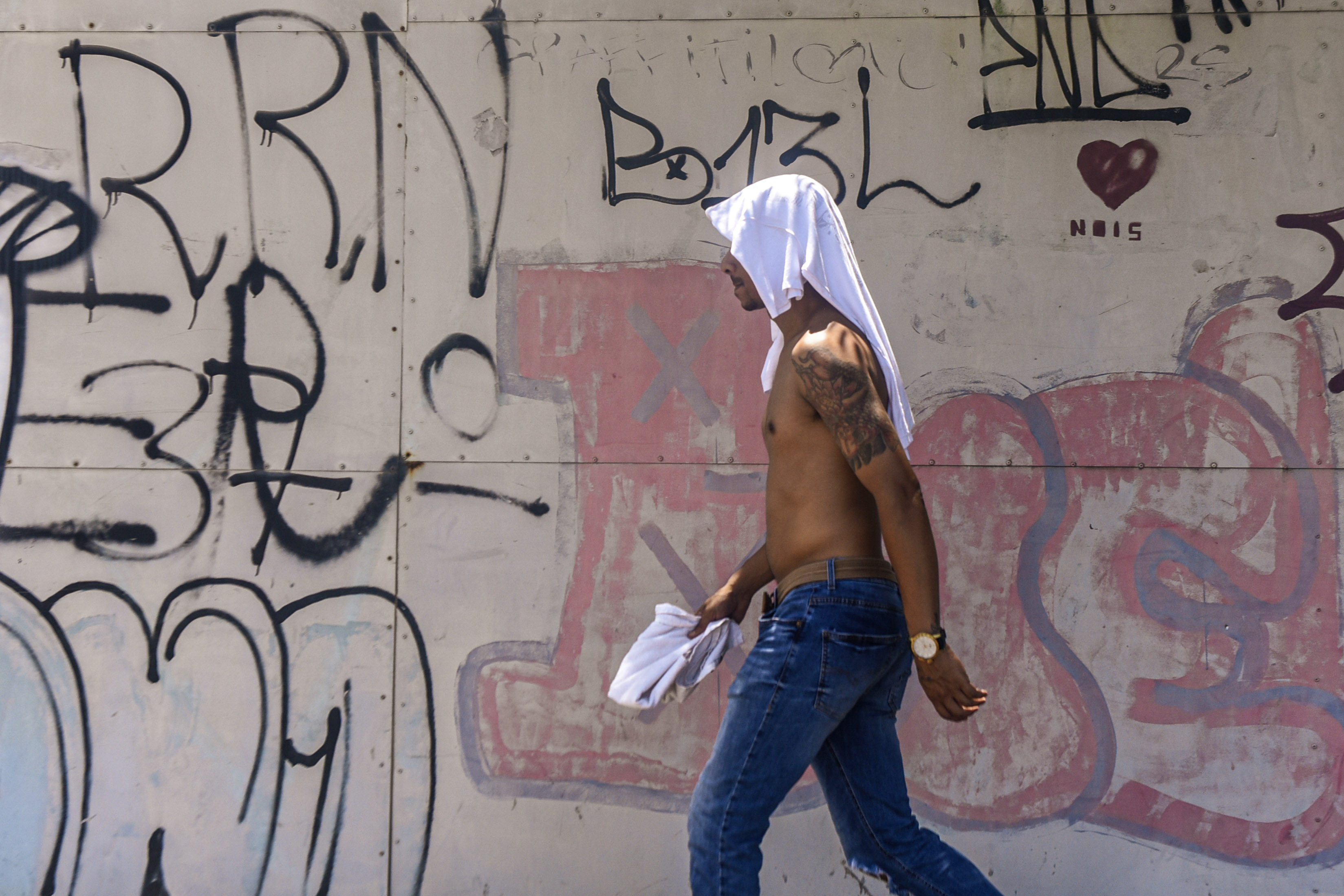 Homem com camisa na cabeça caminha pelo Centro de Vitória