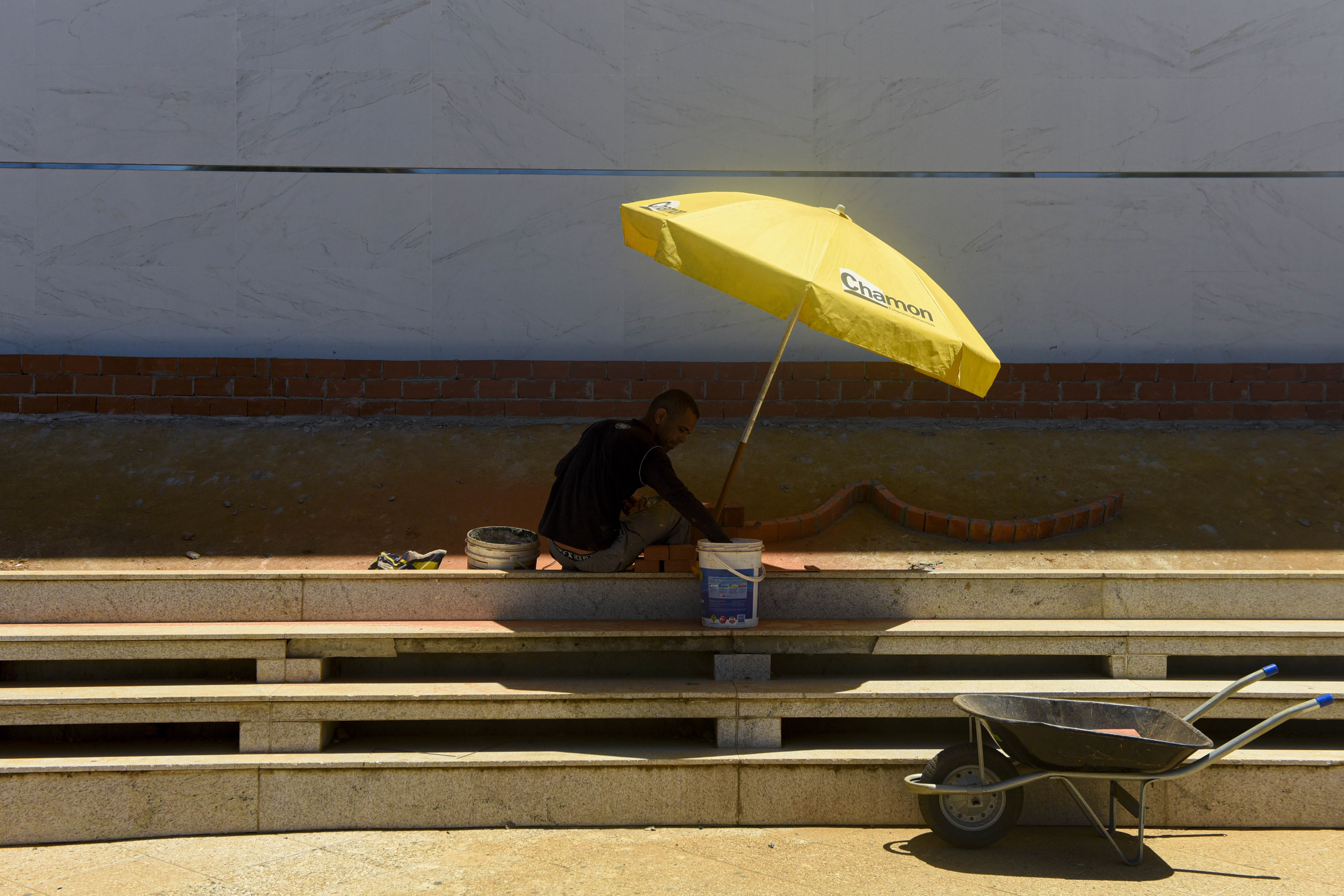 Trabalhador se protege do sol na Praia da Costa