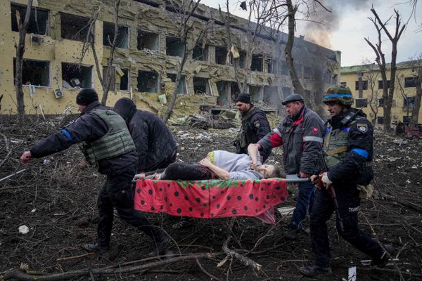 Funcionários e voluntários de emergência ucranianos carregam uma mulher grávida ferida da maternidade danificada pelo bombardeio em Mariupol, na Ucrânia, nesta quarta-feira (9) 
