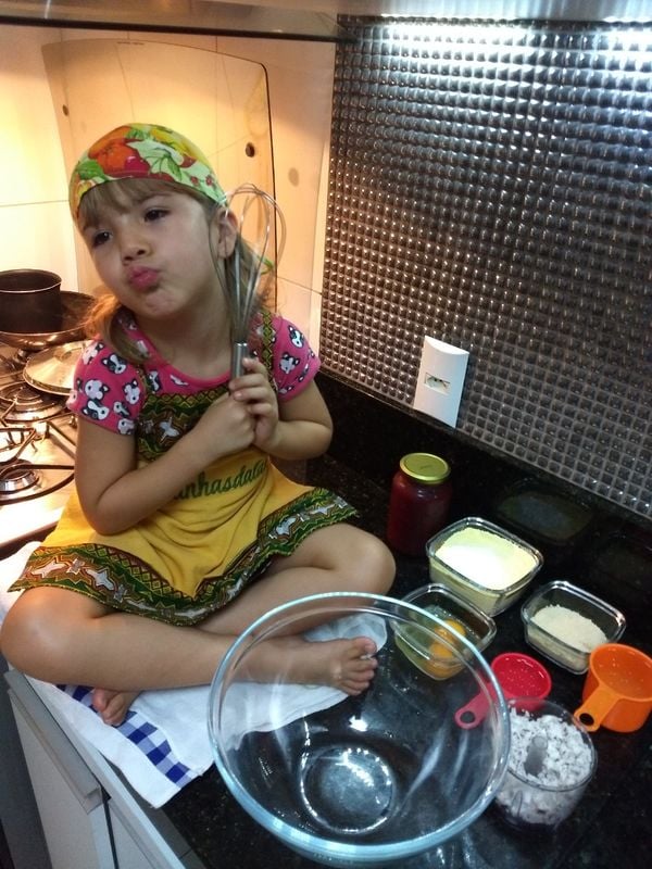A pequena Laura de 6 anos ajudando a mãe na cozinha