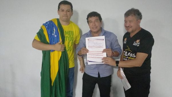 Gilvan da Federal, Magno Malta e Carlos Salvador exibem a ficha de filiação do vereador ao PL
