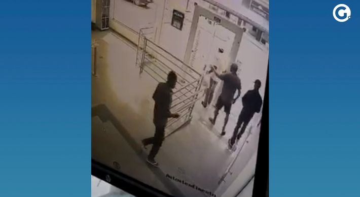 Câmera de segurança do banco registrou o momento em que a vítima é cercada por três homens. O banco informou que vai ressarcir o valor roubado