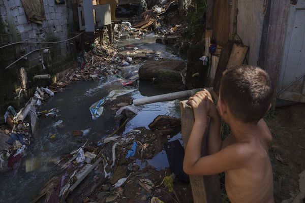 Criança ao lado de córrego na favela da 13, em Osasco, na Grande São Paulo.
