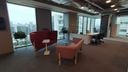 Ambiente corporativo com dois sofás assimétricos. Um vermelho e um rosa. (Projeto de Melissa Francani)