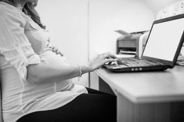 Mulher grávida usando o computador