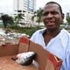 Em situação de rua, Fernando Martins mostra cabeça de peixe que vai comer